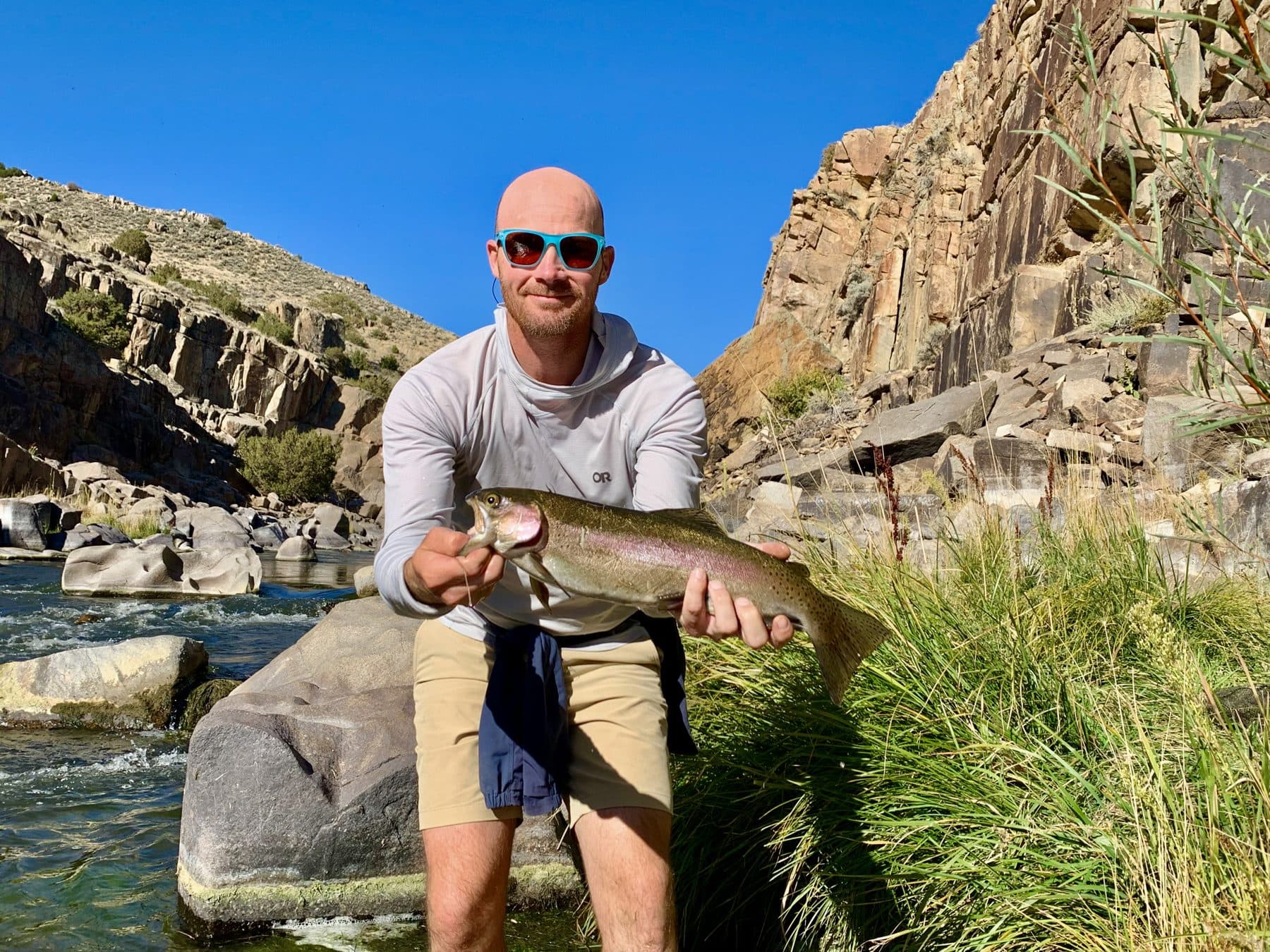 An angler holding up a rainbow trout catch
